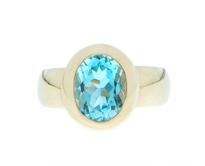 Yellow gold ring with an oval blue topaz