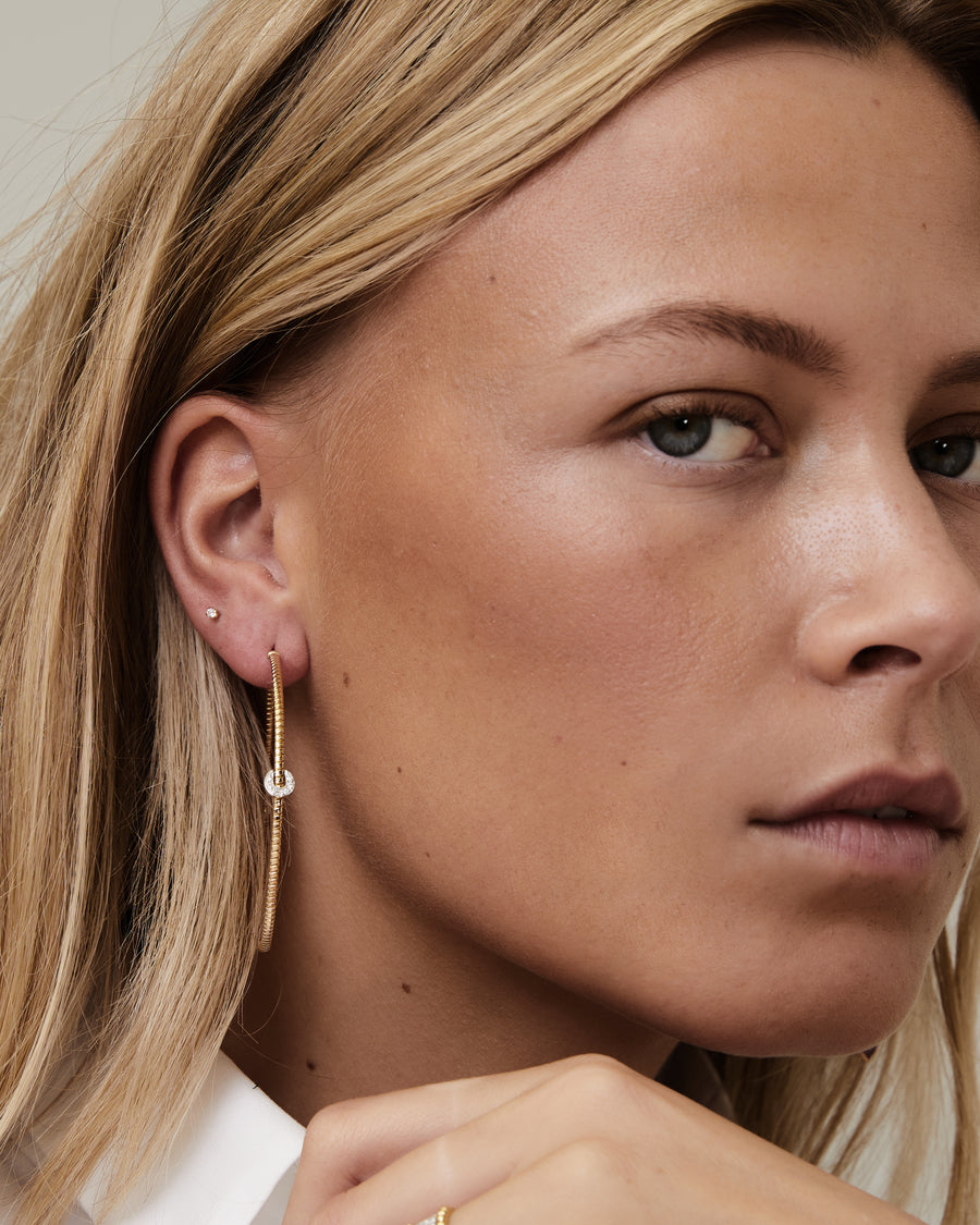 Yellow gold tubo hoops with a diamond piece