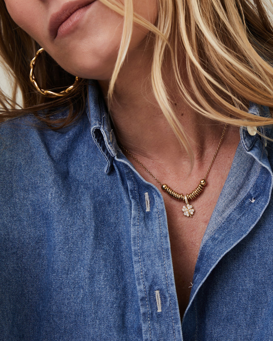 Geelgouden ketting met ringen en een diamanten klaverhanger