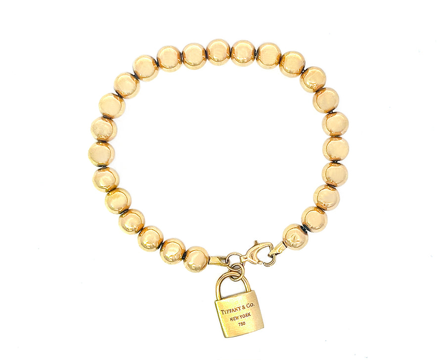 Yellow gold ball bracelet with a lock charm