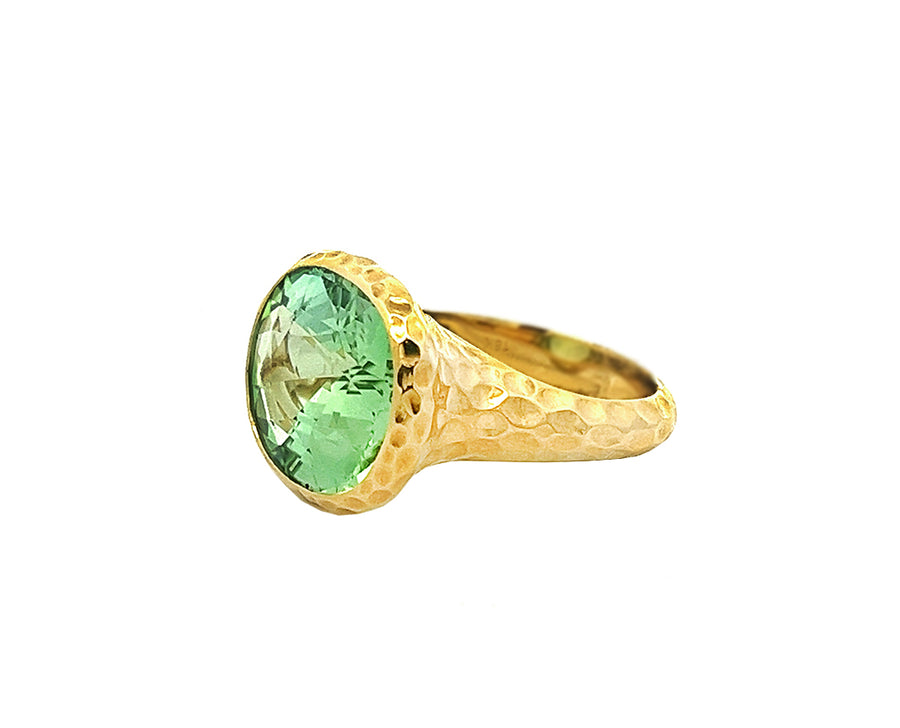 Yellow gold hammered ring with a light green tourmaline