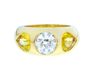 Yellow gold gypsy ring with a diamond and two yellow sapphires